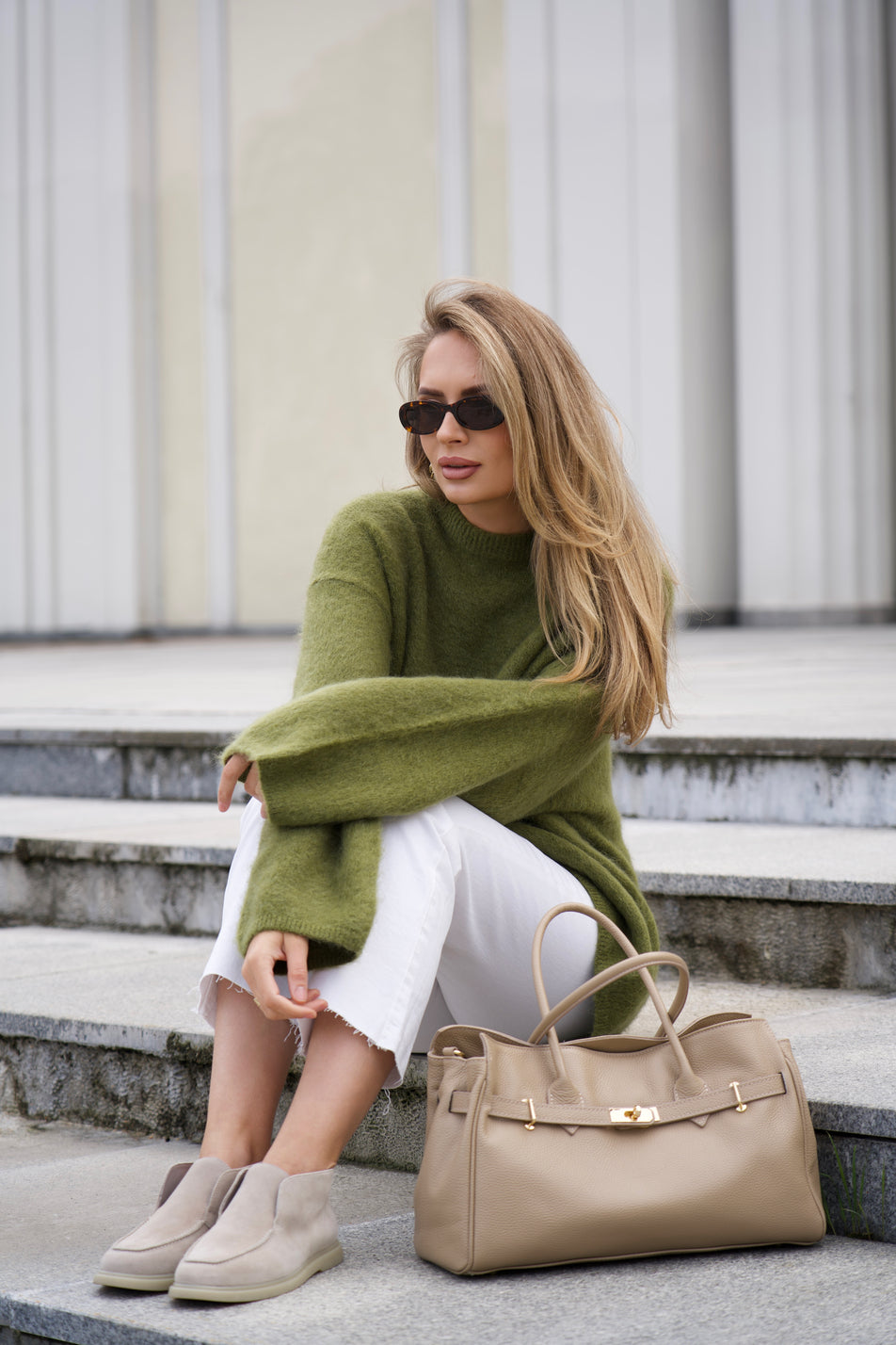 Sitzendes Model auf Treppenstufen mit der großen beigen Echtleder-Handtasche neben sich