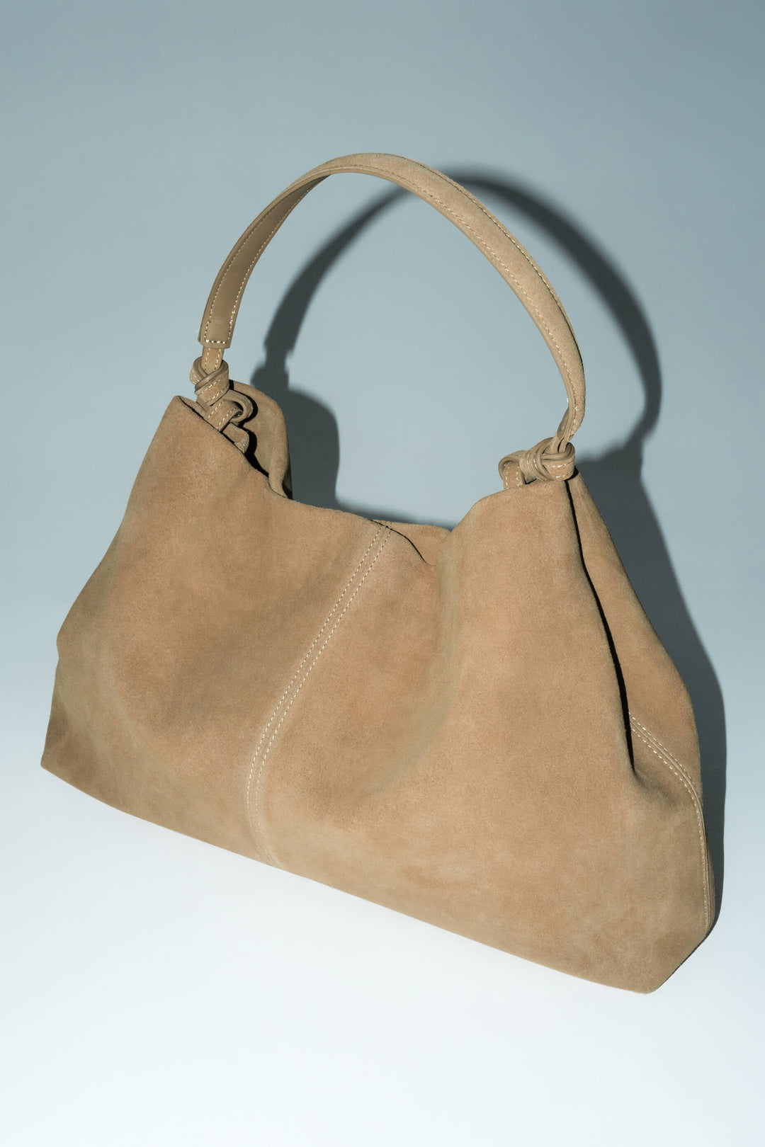 Schräge Ansicht der beigen Damen-Shopper-Tasche aus samtigem Naturvelours mit Tragehenkeln.