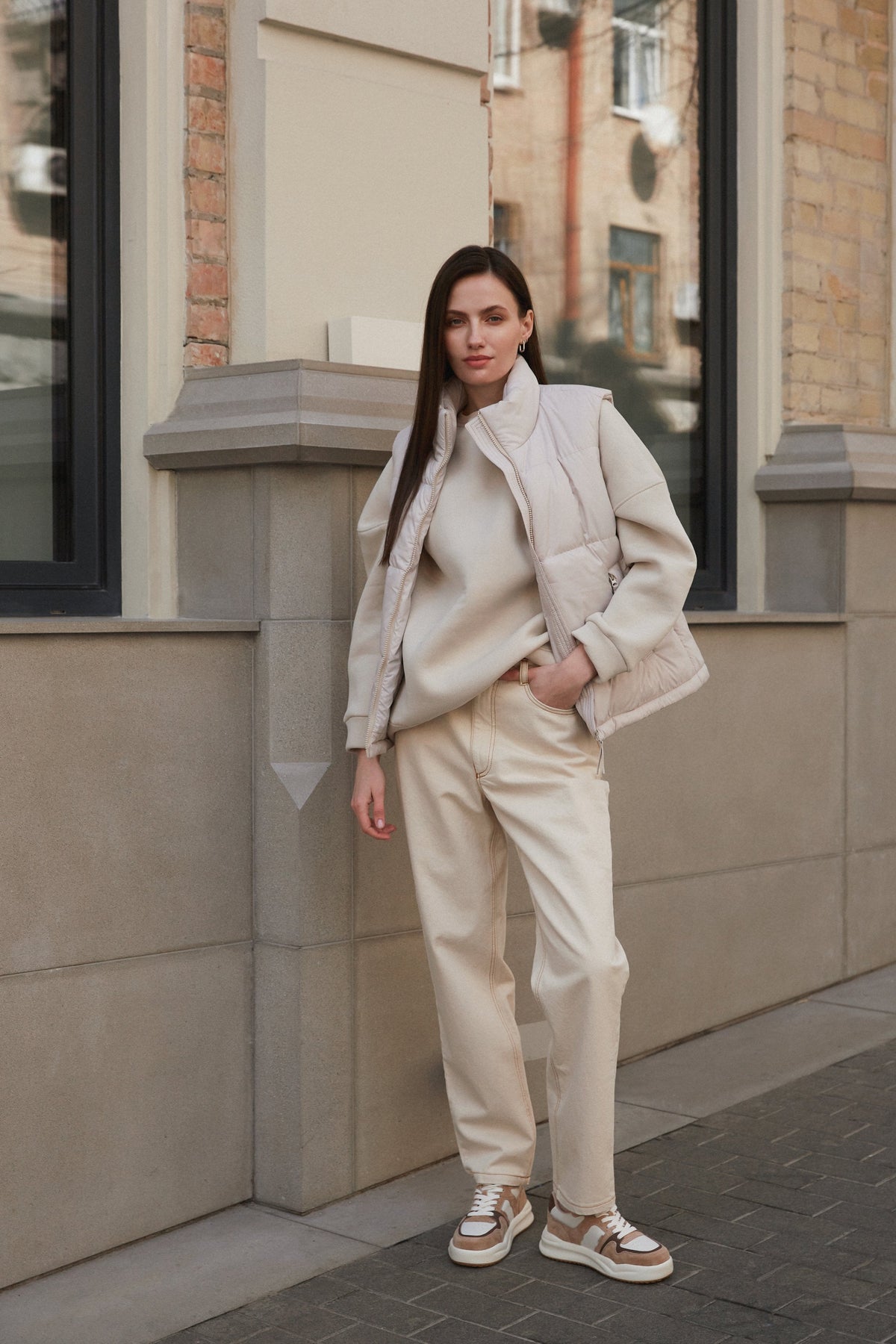 Model in beigefarbenem Outfit trägt die beige-weißen Damen-Sneaker aus Echtleder
