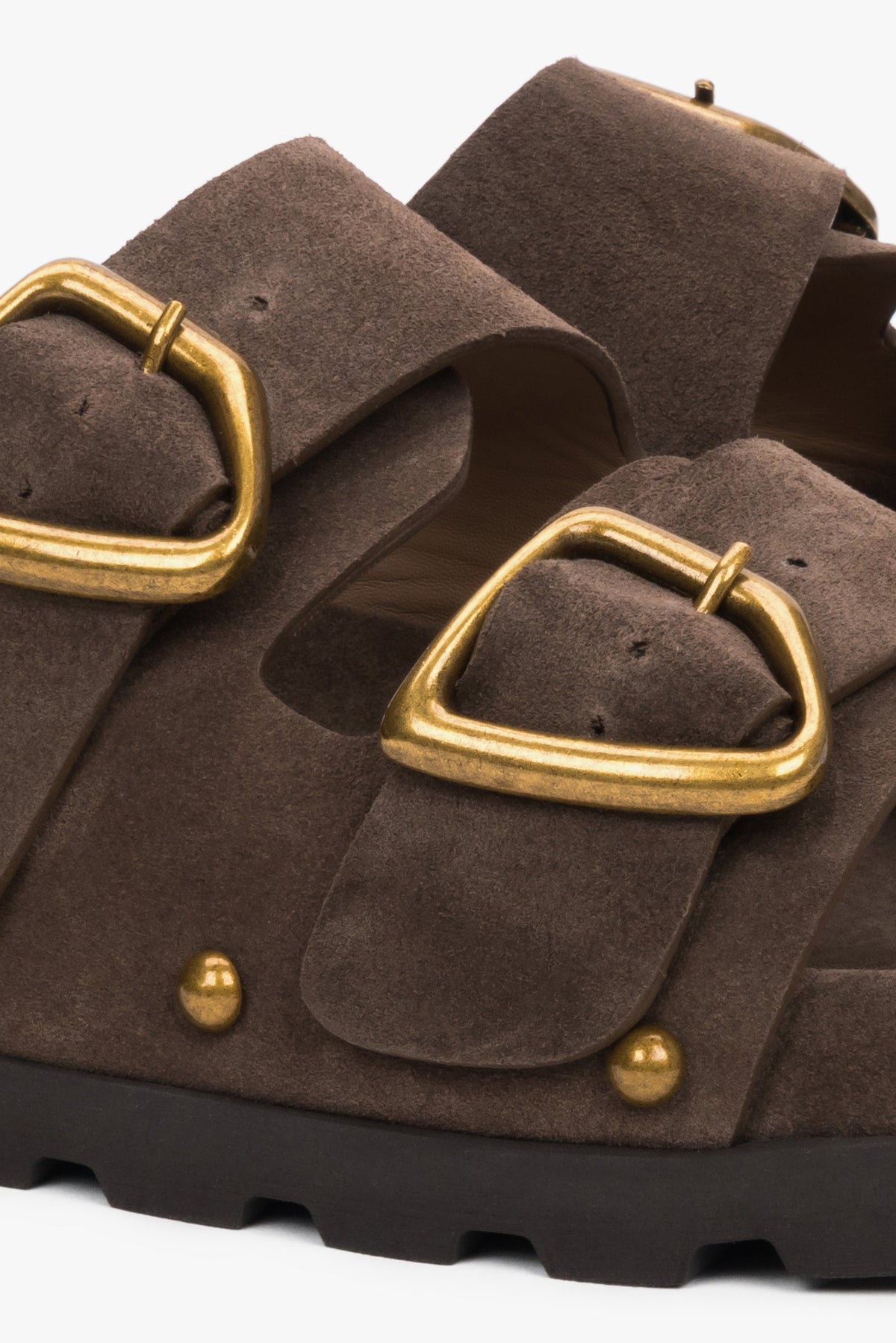 Detailaufnahme brauner Damen-Pantoletten mit goldfarbener Schnalle und Nieten