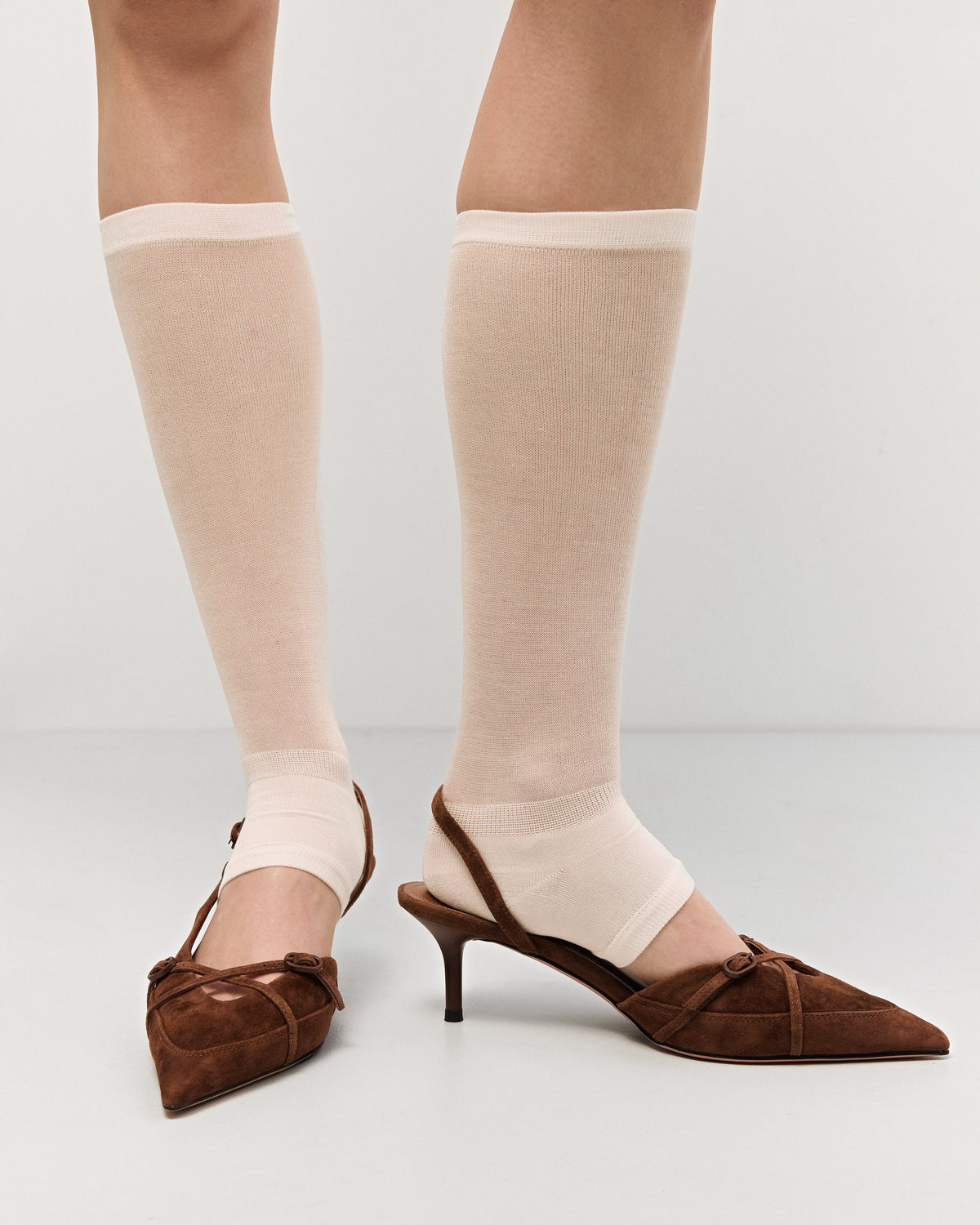 Estro braune Slingback-Pumps mit niedrigem Absatz für Damen – am Fuß präsentiert.