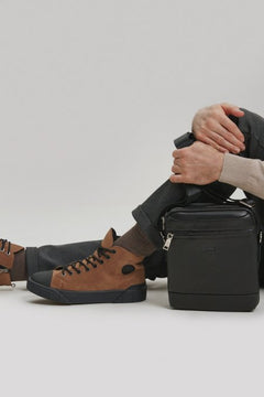 Model trägt die braunen hohen Herren-Winter-Sneaker aus Nubukleder zum lässigen Outfit