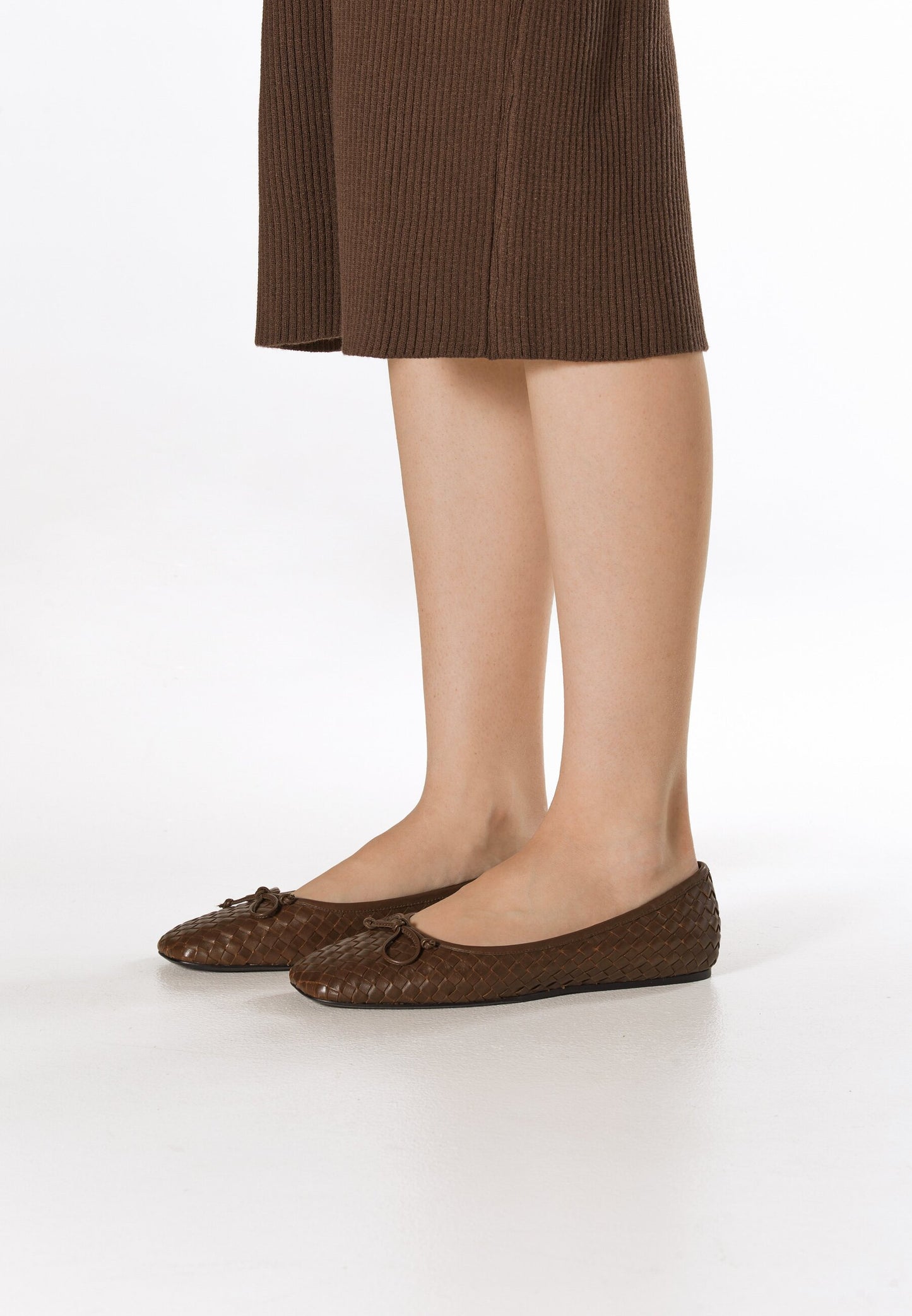 Dunkelbraune Damen-Ballerinas von Estro aus geflochtenem Echtleder – am Fuß präsentiert.