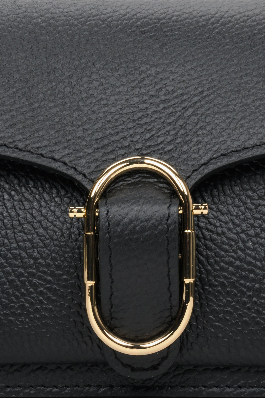 Kleine schwarze Damenhandtasche – Nahaufnahme der goldenen Applikation.