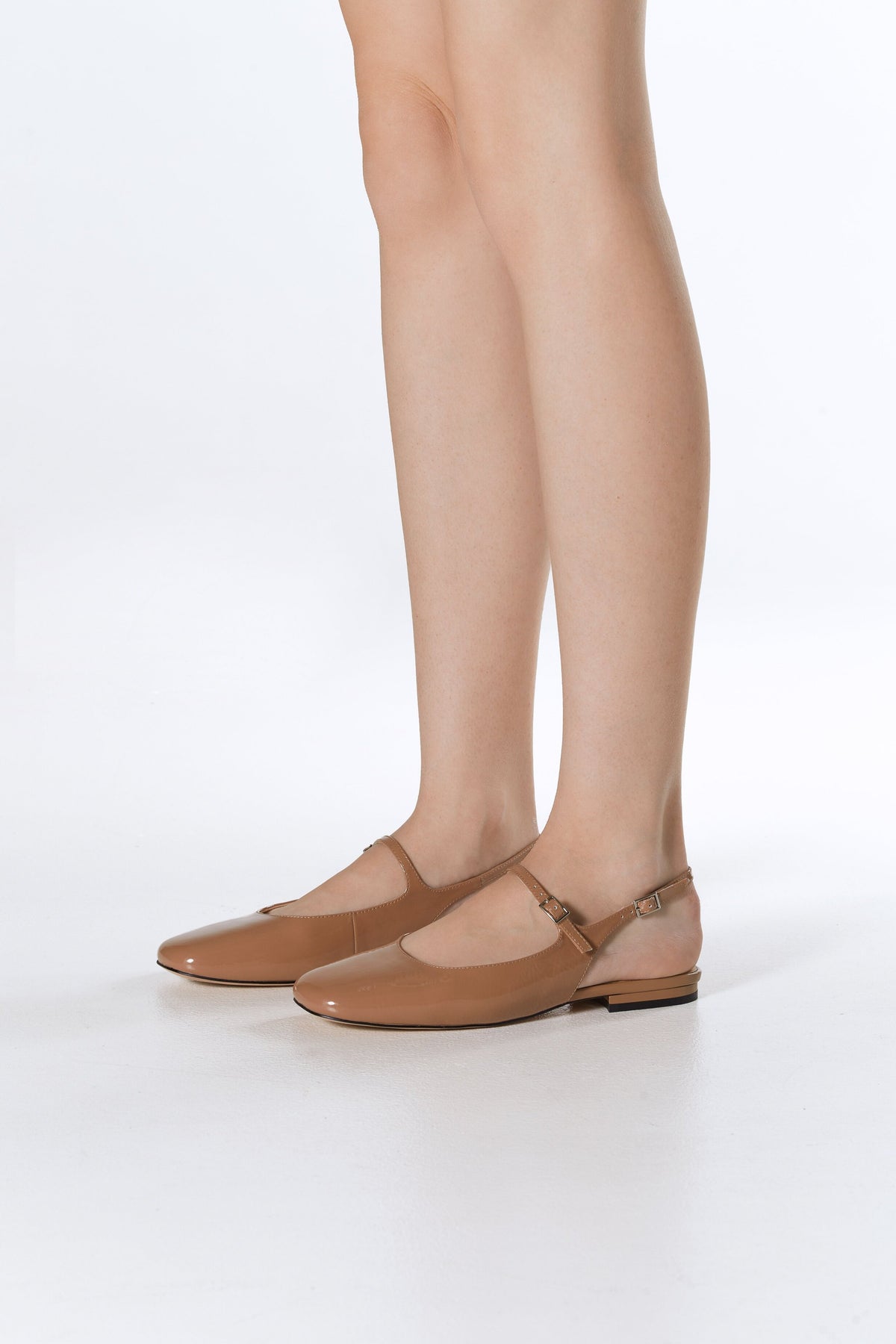 Estro Slingback-Ballerinas aus braunem Lackleder – Präsentation am Fuß.
