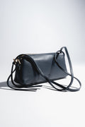 Schrägansicht der dunkelblauen, länglichen Damen-Schultertasche aus genarbtem italienischem Echtleder mit langem Riemen 