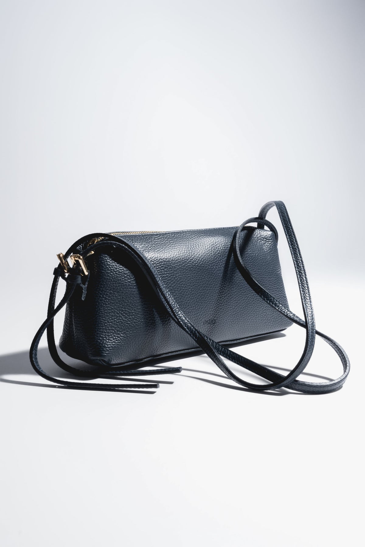 Schrägansicht der dunkelblauen, länglichen Damen-Schultertasche aus genarbtem italienischem Echtleder mit langem Riemen 