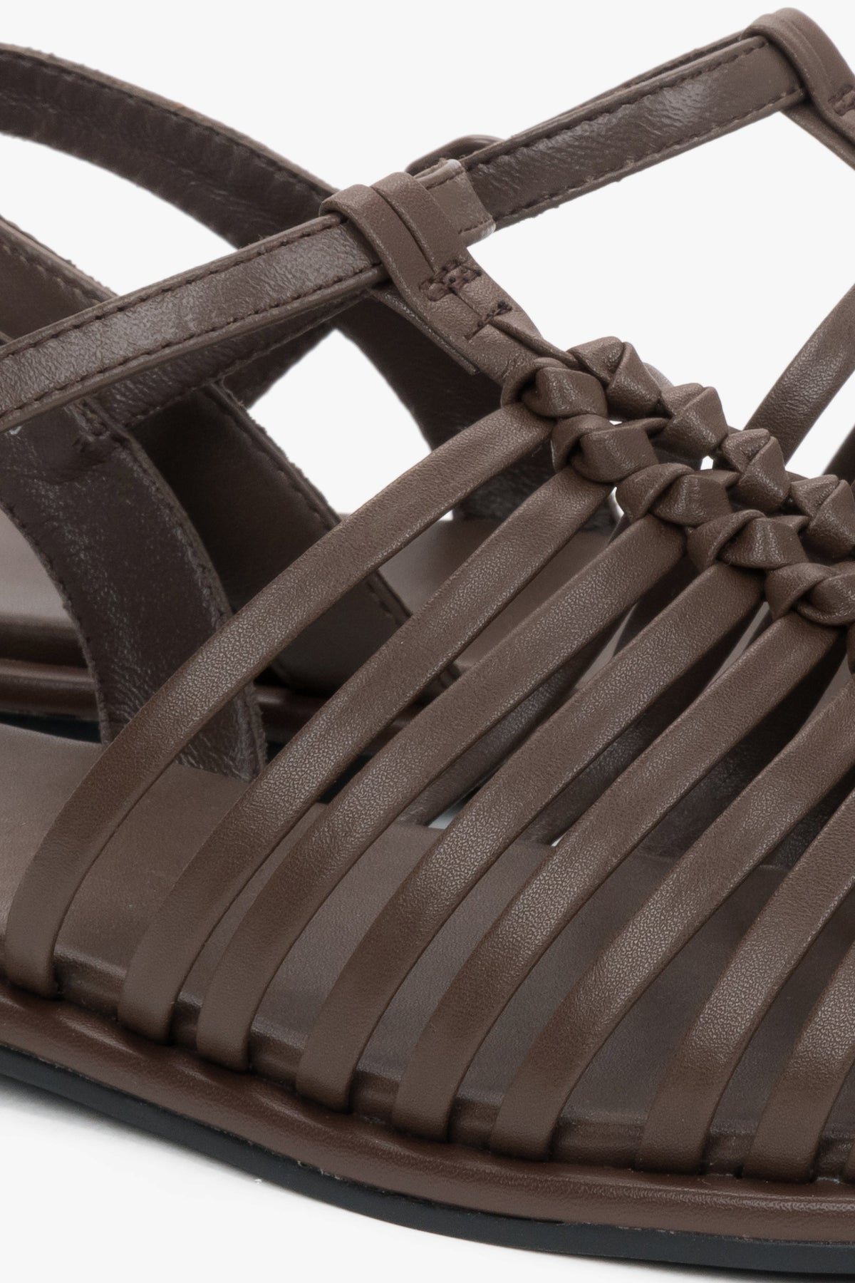 Nahaufnahme der kunstvoll geflochtenen Echtleder-Riemen an der geschlossenen Schuhspitze.