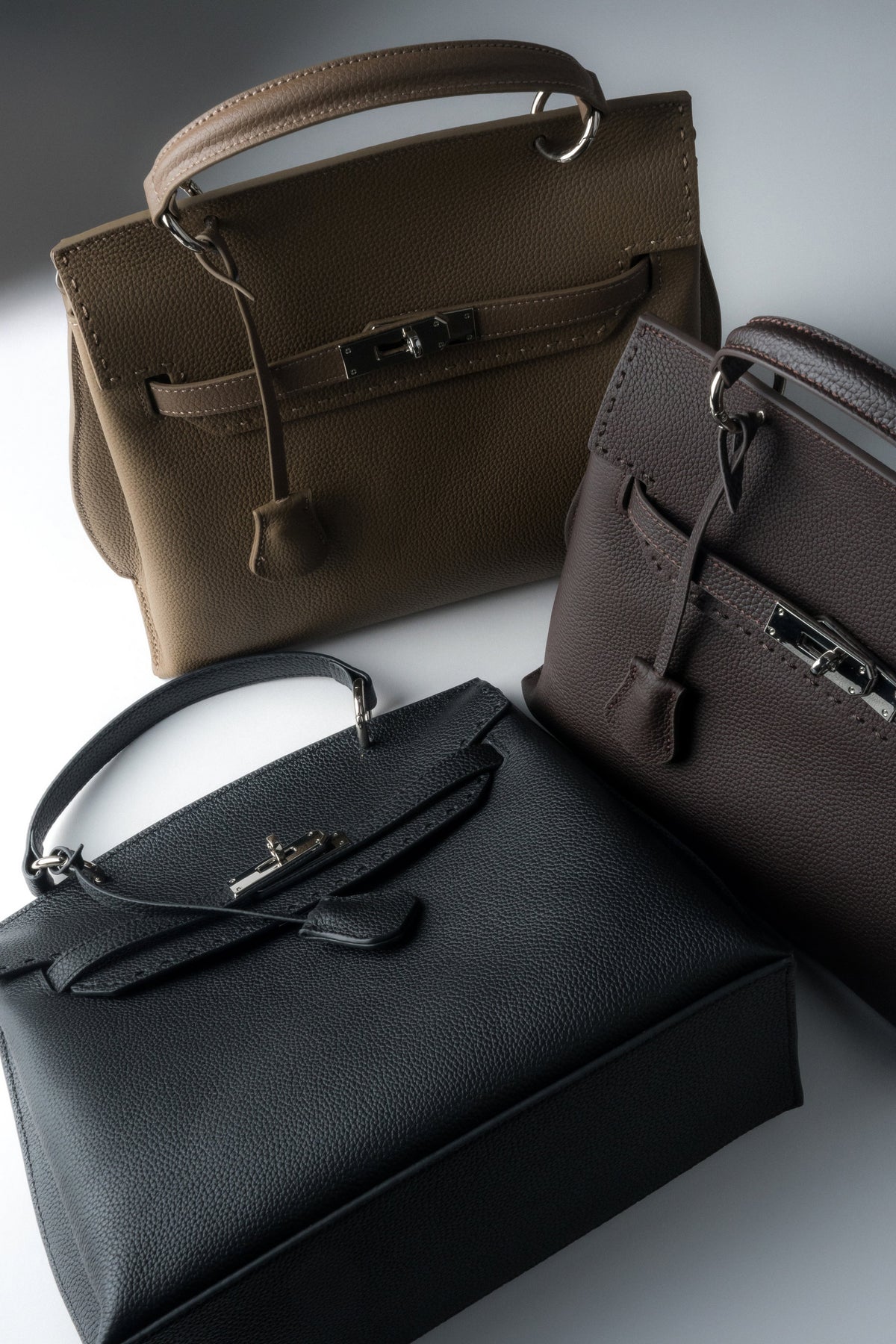 Gruppenbild verschiedener Estro Handtaschen in Schwarz und Dunkelbraun.