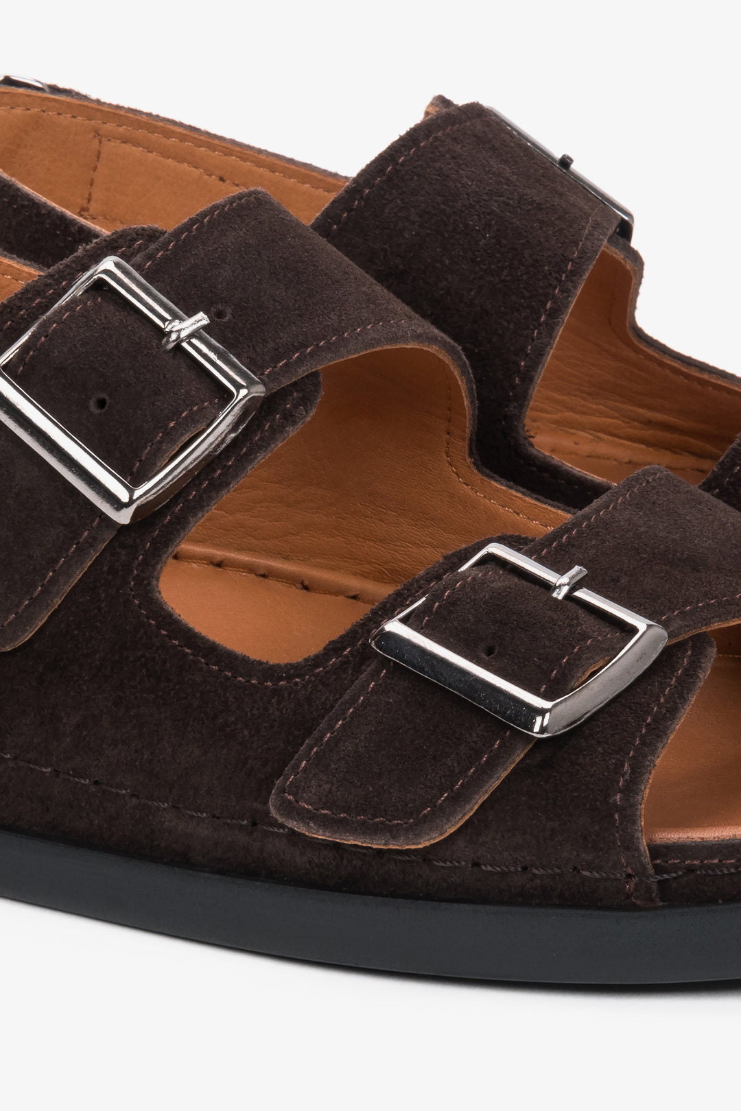 Detailansicht der verstellbaren Riemen und Zierschnallen der dunkelbraunen Veloursleder-Sandalen