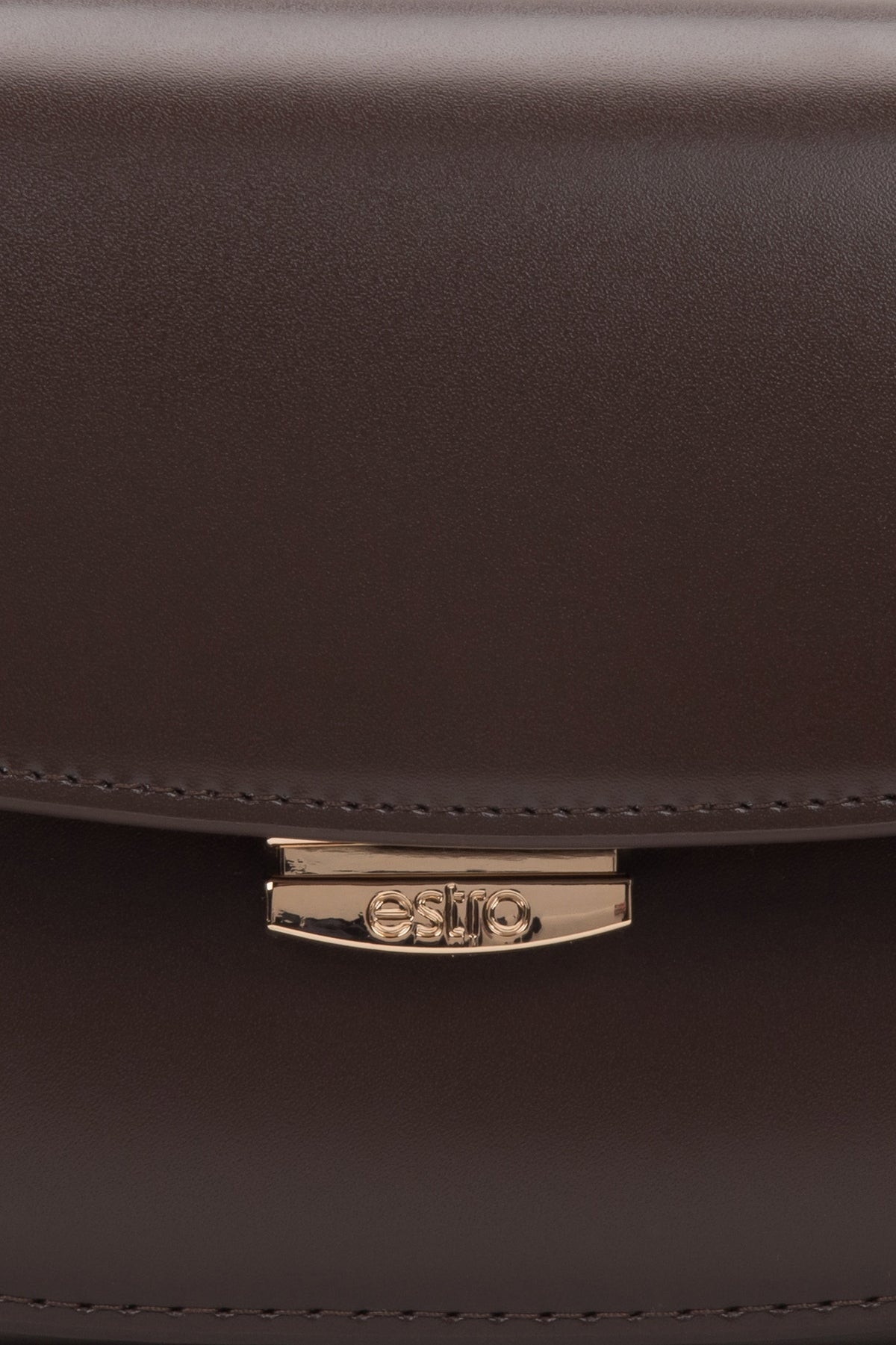 Nahaufnahme des Druckknopfverschlusses der dunkelbraunen Ledertasche.