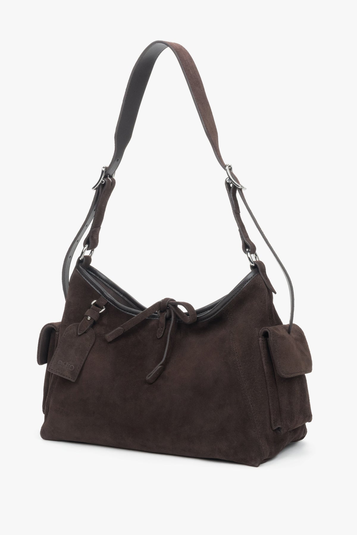 Schräge Ansicht der kompakten Veloursledertasche, die den praktischen Pin an den Henkeln zeigt.