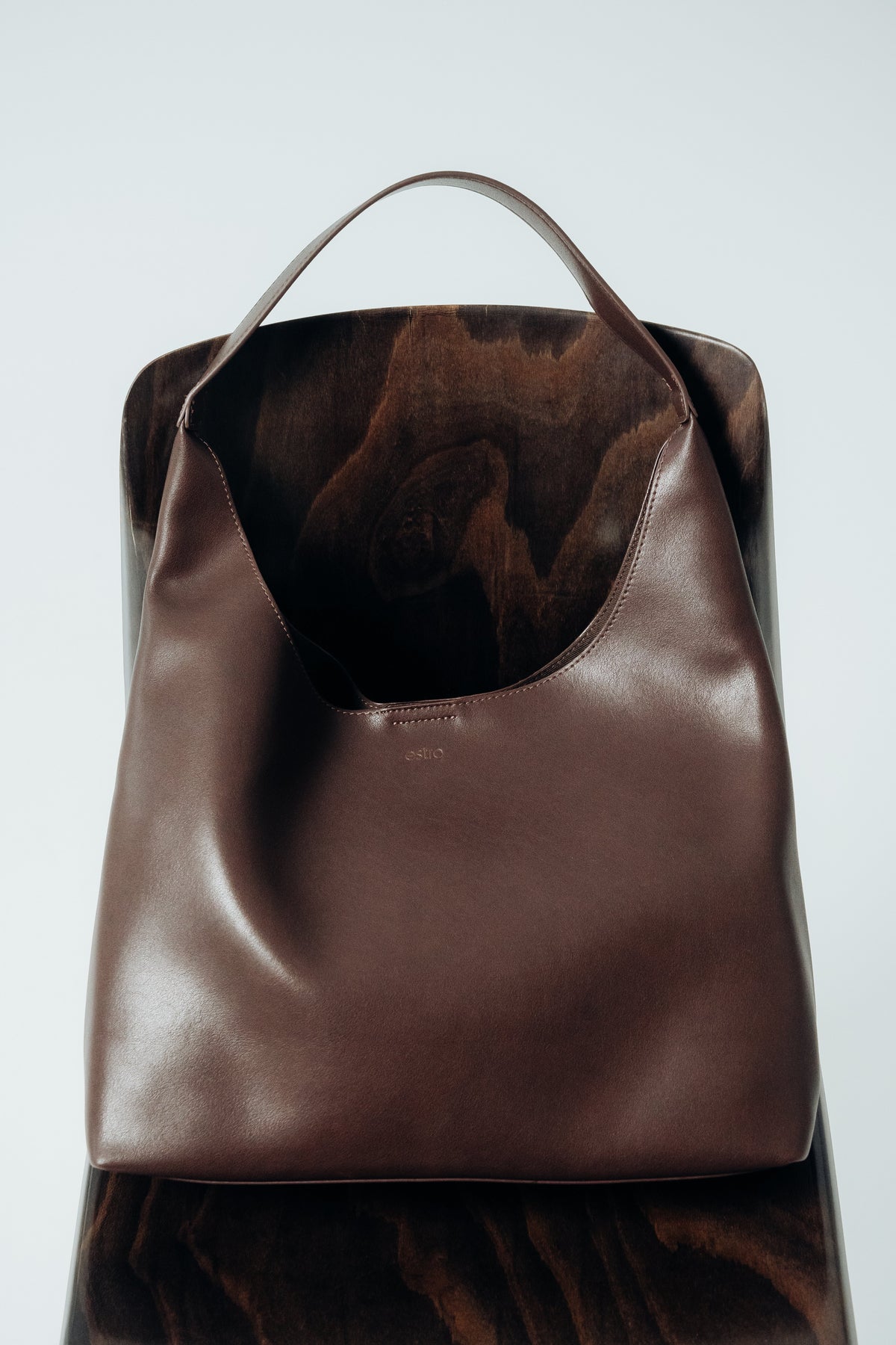 Seitliches Profil der dunkelbraunen Damen-Lederhandtasche mit breitem Schulterriemen