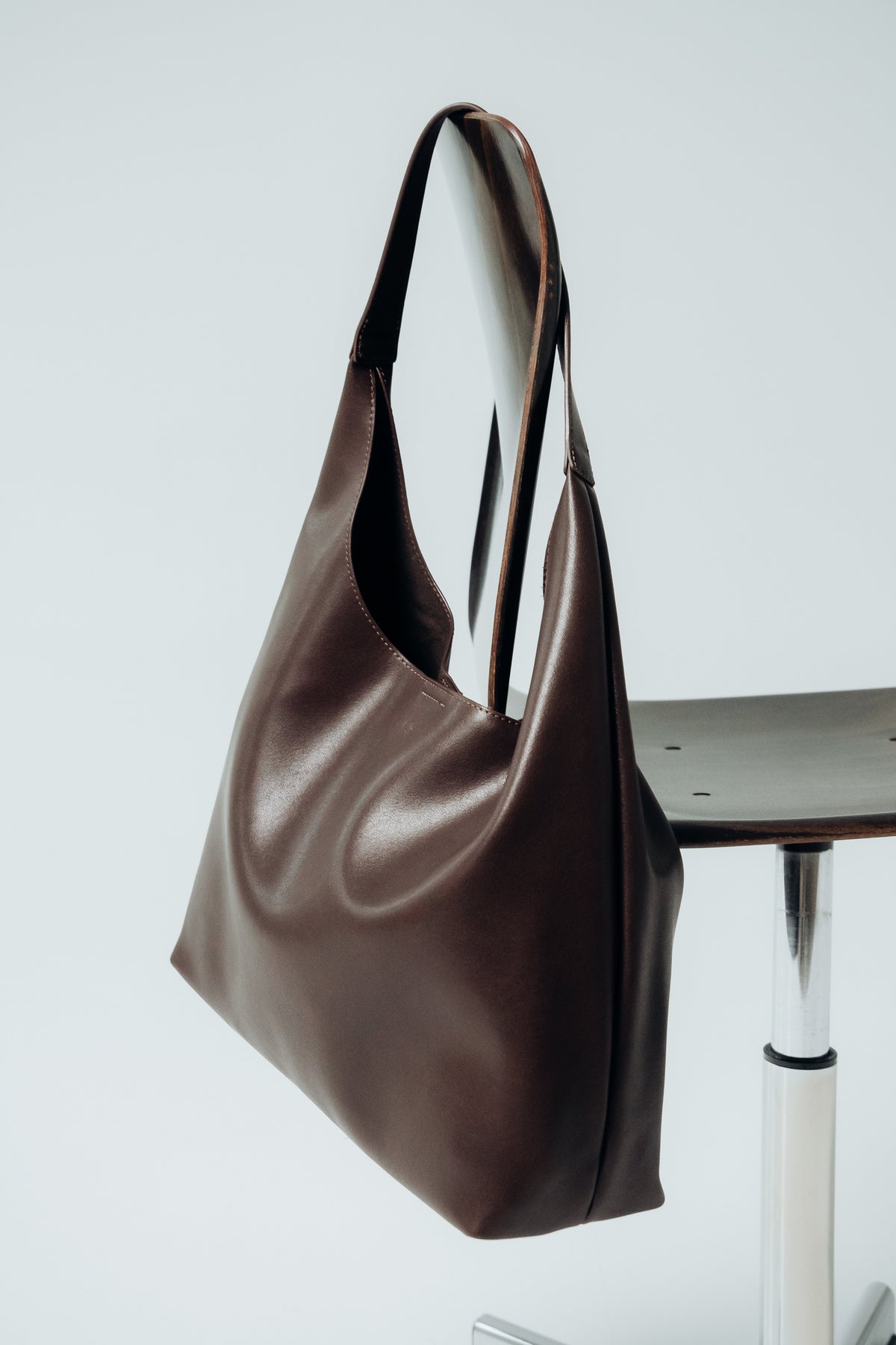 Frontale Ansicht der dunkelbraunen Damen-Shopper-Tasche aus Glattleder auf hellem Hintergrund