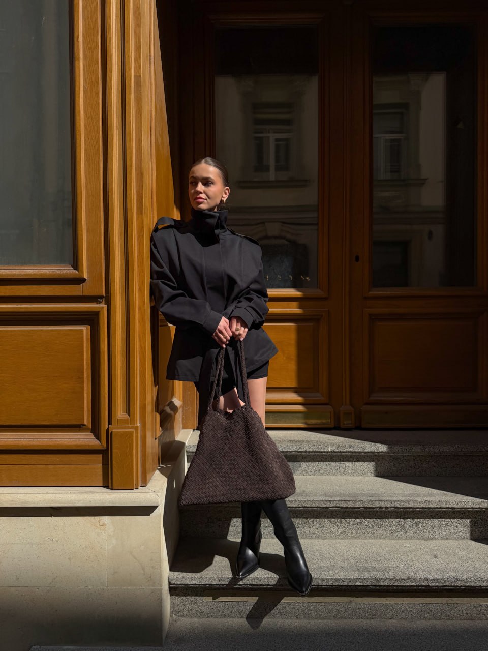 Lifestyle-Aufnahme des Models, das die auffällige dunkelbraune Velourstasche elegant trägt.