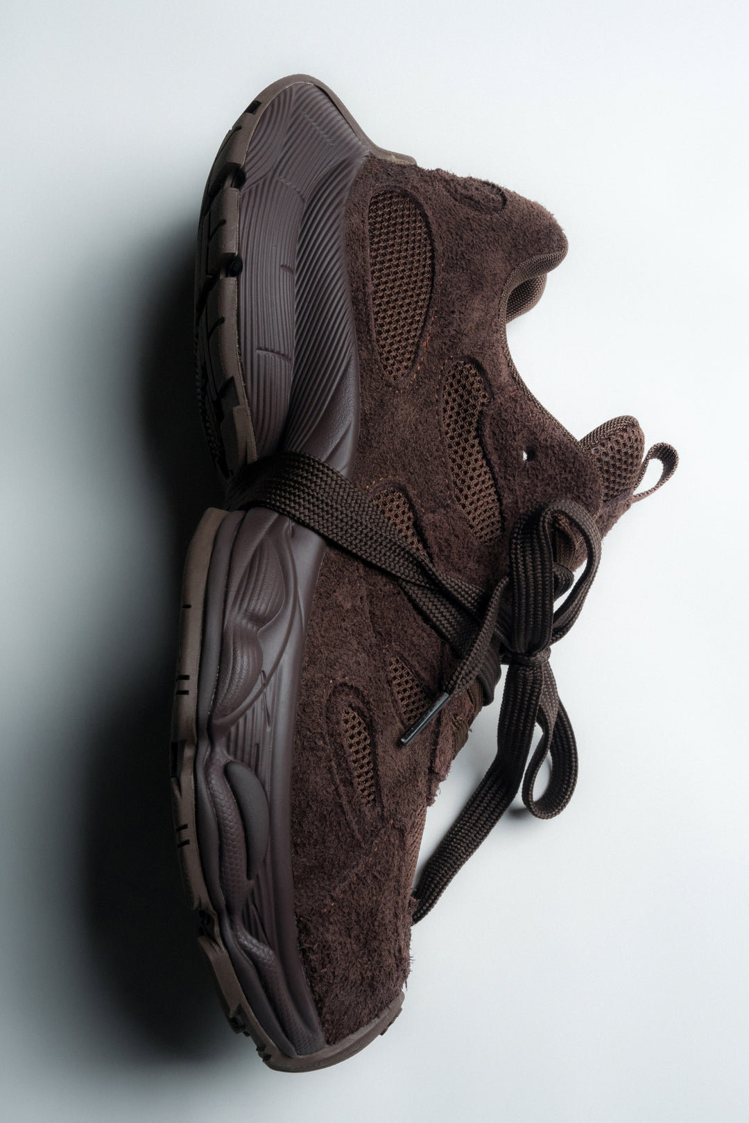 Künstlerische Schrägansicht von oben auf die dunkelbraunen Velours-Sneaker