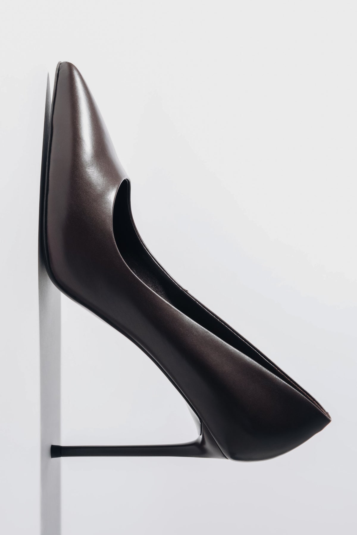 Vertikale Detailaufnahme des dunkelbraunen Stilettos mit Fokus auf die Gummisohle und den feinen Pfennigabsatz 