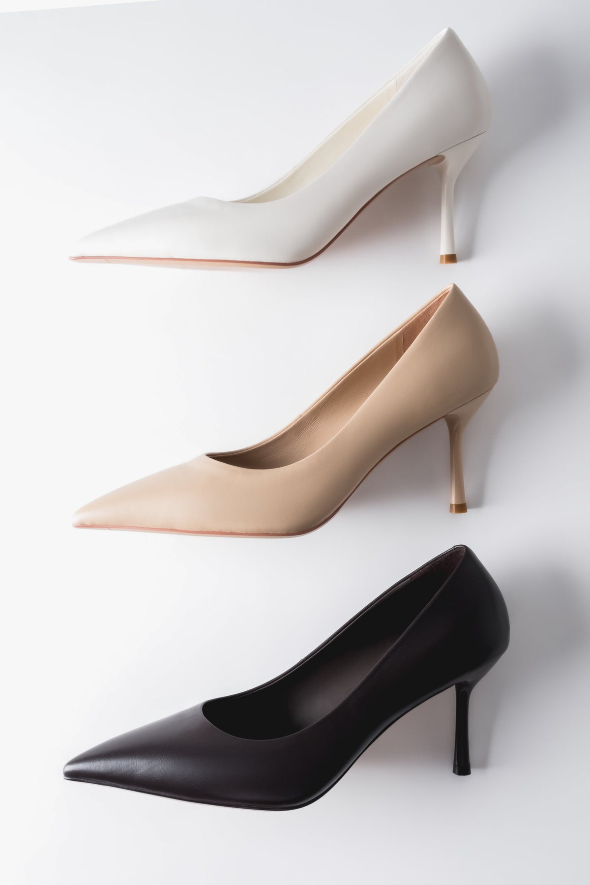 Gruppenaufnahme der Stilettos in drei verschiedenen Farben (Beige, Weiß, Dunkelbraun) im harmonischen Arrangement 
