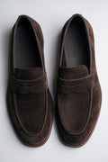 Draufsicht auf das Paar dunkelbrauner Herren-Loafer aus weichem Veloursleder.