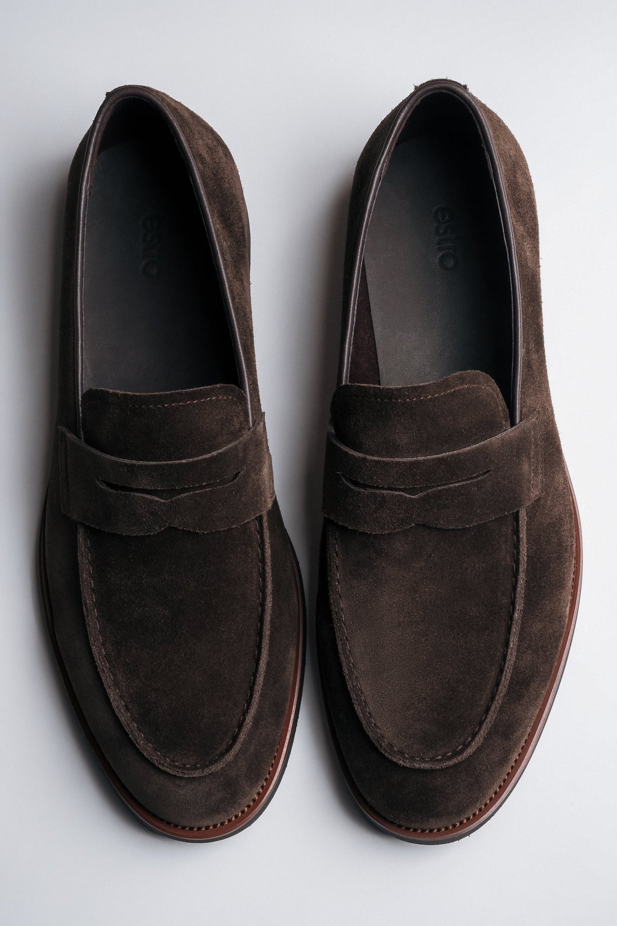 Draufsicht auf das Paar dunkelbrauner Herren-Loafer aus weichem Veloursleder.
