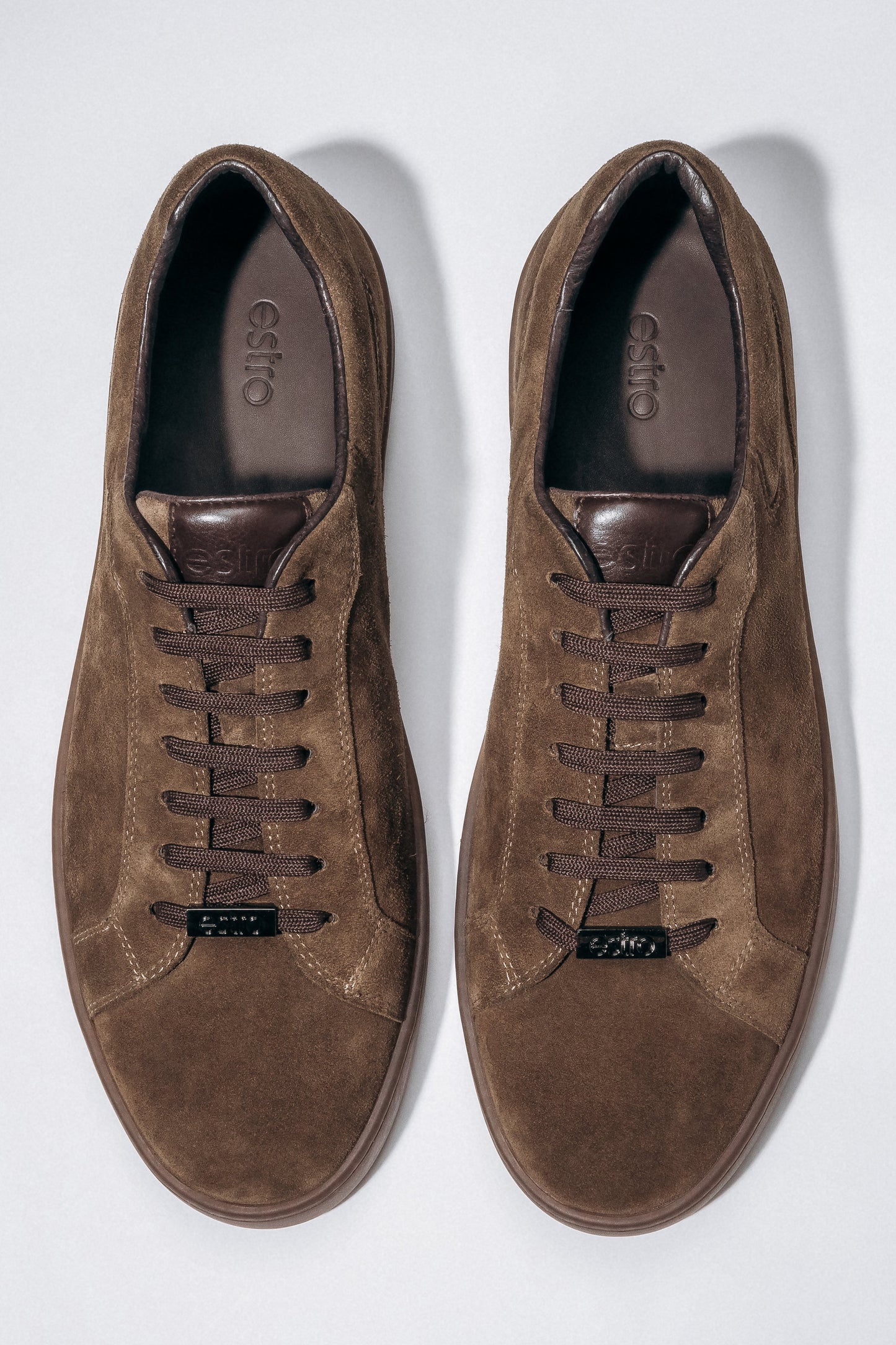 Draufsicht auf das Paar dunkelbrauner Herren-Sneaker aus weichem Veloursleder.