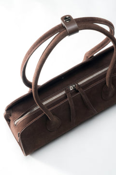 Ansicht der Henkel mit dem silbernen Pin, der die Riemen der Schultertasche zusammenhält.