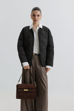 Model mit Steppjacke trägt die dunkelbraune Schultertasche aus italienischem Premium-Velours lässig an der Schulter