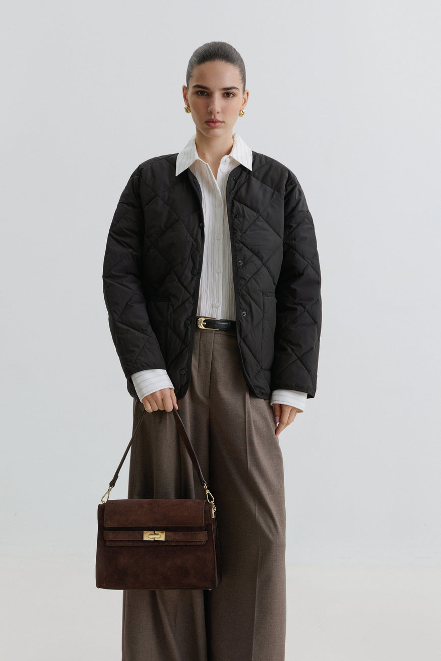 Model mit Steppjacke trägt die dunkelbraune Schultertasche aus italienischem Premium-Velours lässig an der Schulter