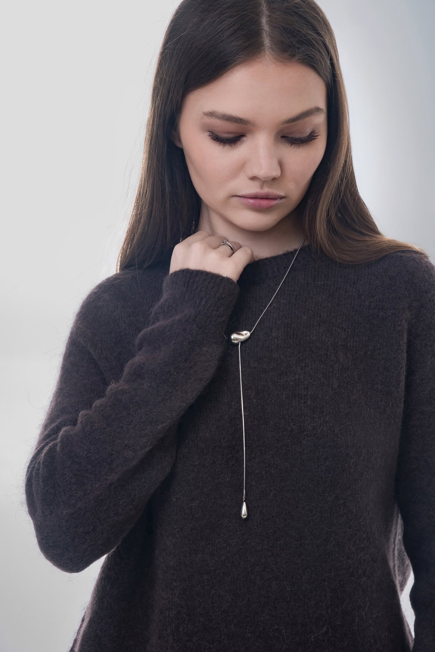 Nahaufnahme des Models mit eleganter Halskette zur Veranschaulichung der Strickstruktur