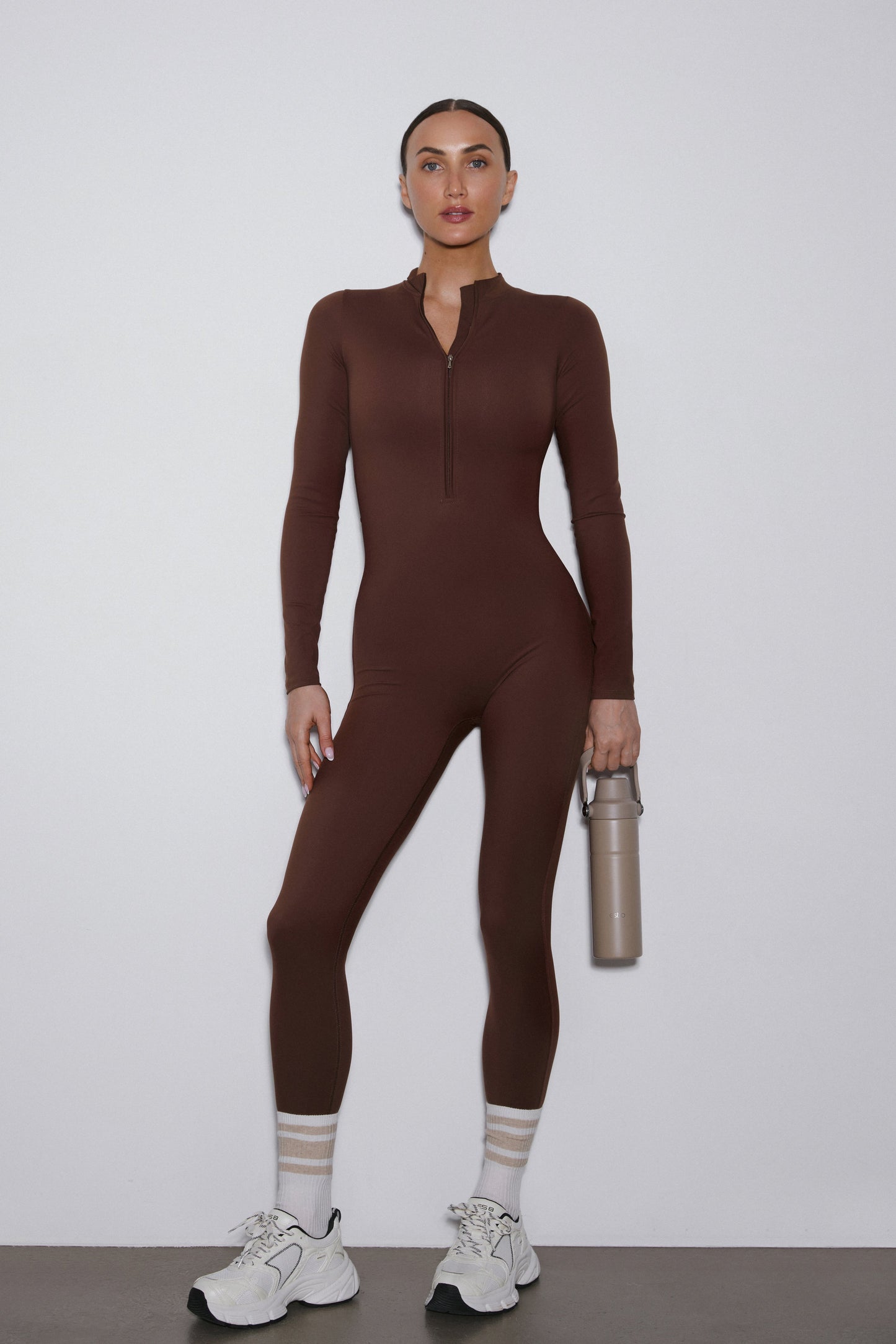 Frontansicht des dunkelbraunen Sport-Jumpsuits für Damen im Slim Fit.