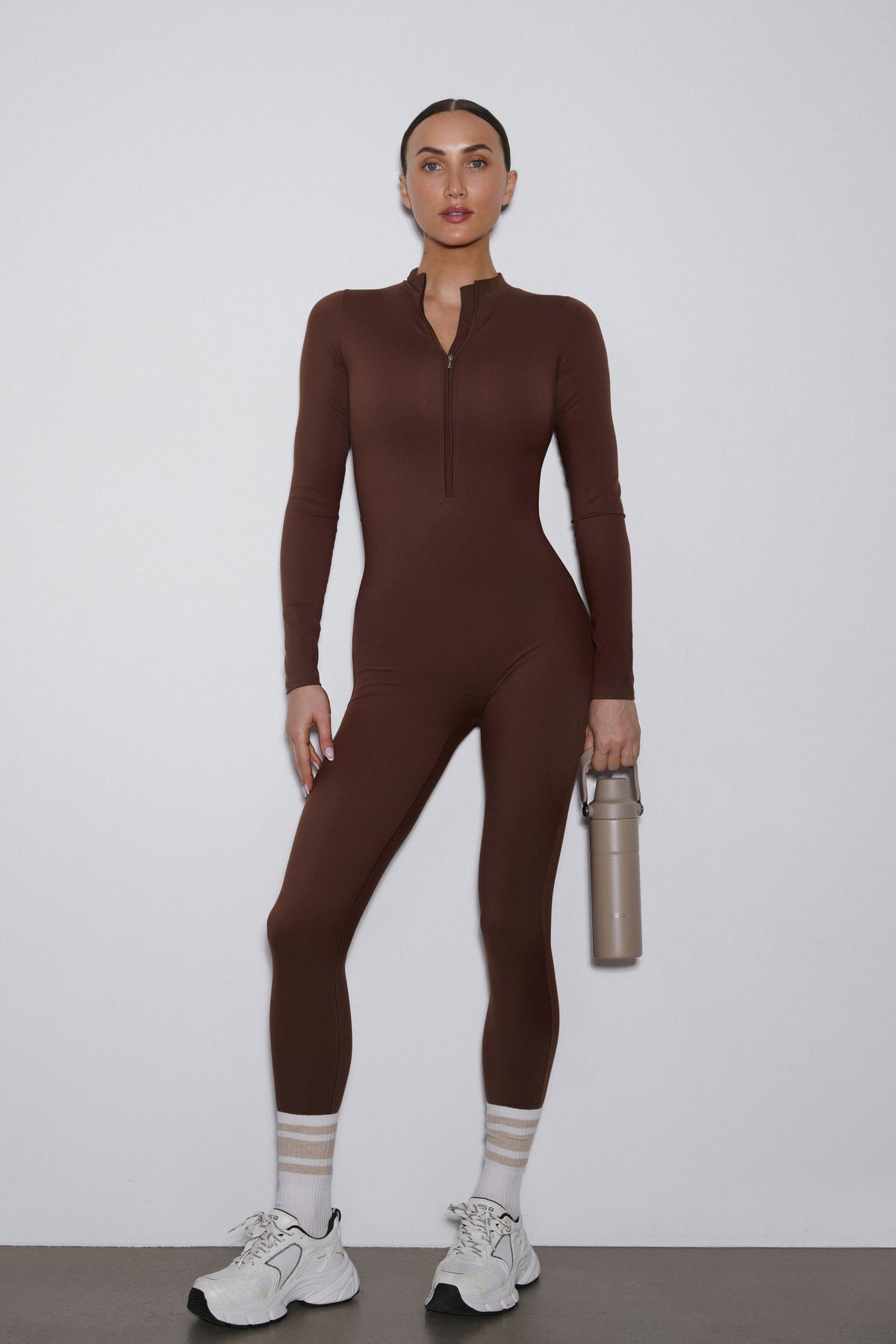 Frontansicht des dunkelbraunen Sport-Jumpsuits für Damen im Slim Fit.