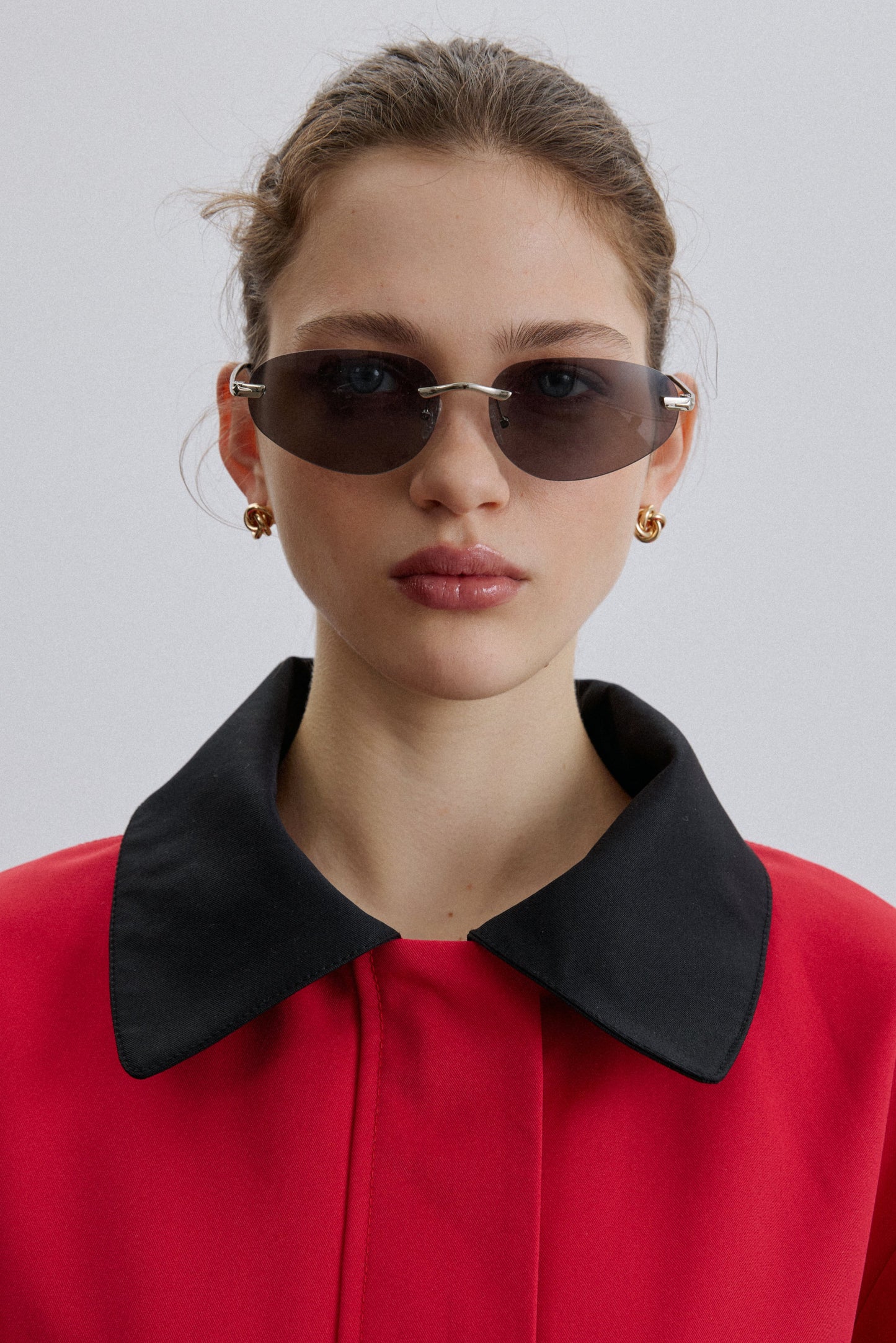 Model trägt die dunkelgraue schmale rahmenlose Damen-Sonnenbrille.