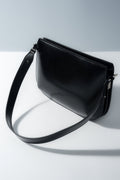 Schräge Ansicht der eleganten schwarzen Damen-Schultertasche aus weichem Echtleder.