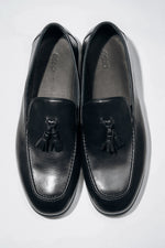 Draufsicht auf das Paar elegante schwarze Herren-Loafer mit Quaste.