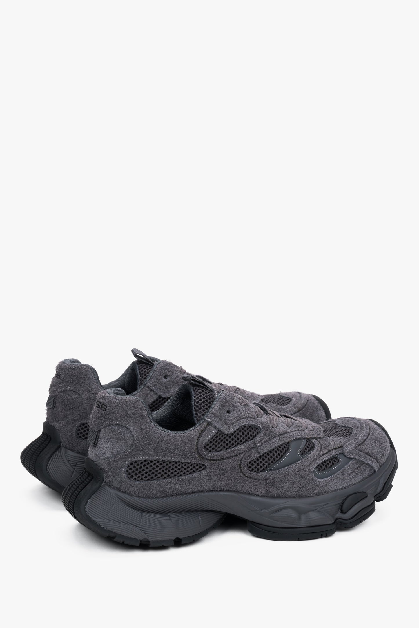 Rückwärtige Schrägansicht der Sneaker mit Fokus auf die klobige Fersenpartie und die profilierte Sohle 