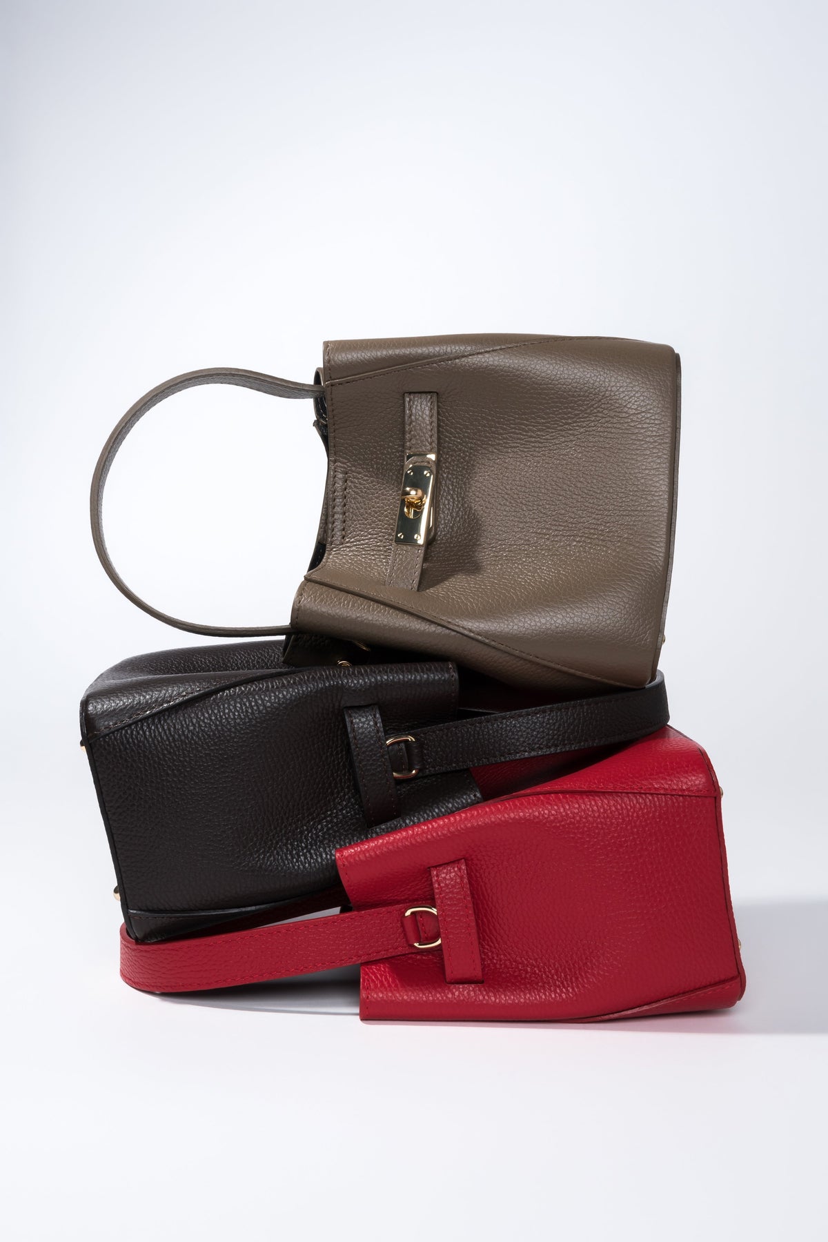 Gruppenaufnahme der eleganten Satchel Bags aus der Kollektion in verschiedenen Erdtönen und ausdrucksstarkem Rot 