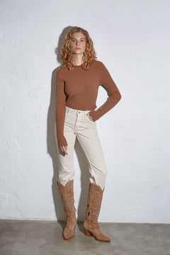 Model trägt die hellbeigen Velours-Cowboystiefel zu einer hellen Jeans und braunem Oberteil
