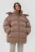 Model präsentiert die offene hellbeige Oversize-Pufferjacke mit hohem Kragen