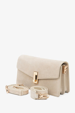 Hellbeige Velours-Schultertasche mit Riemen.