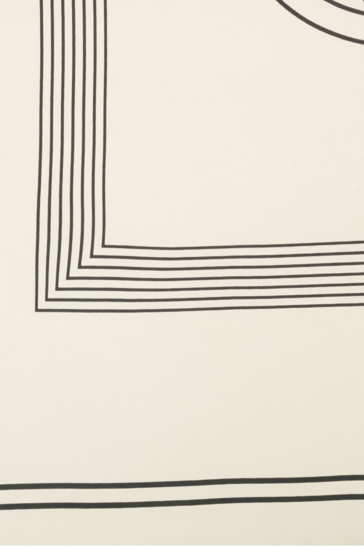 Nahaufnahme des dezenten geometrischen Musters und der schwarzen Linien auf dem hellbeigen Stoff 
