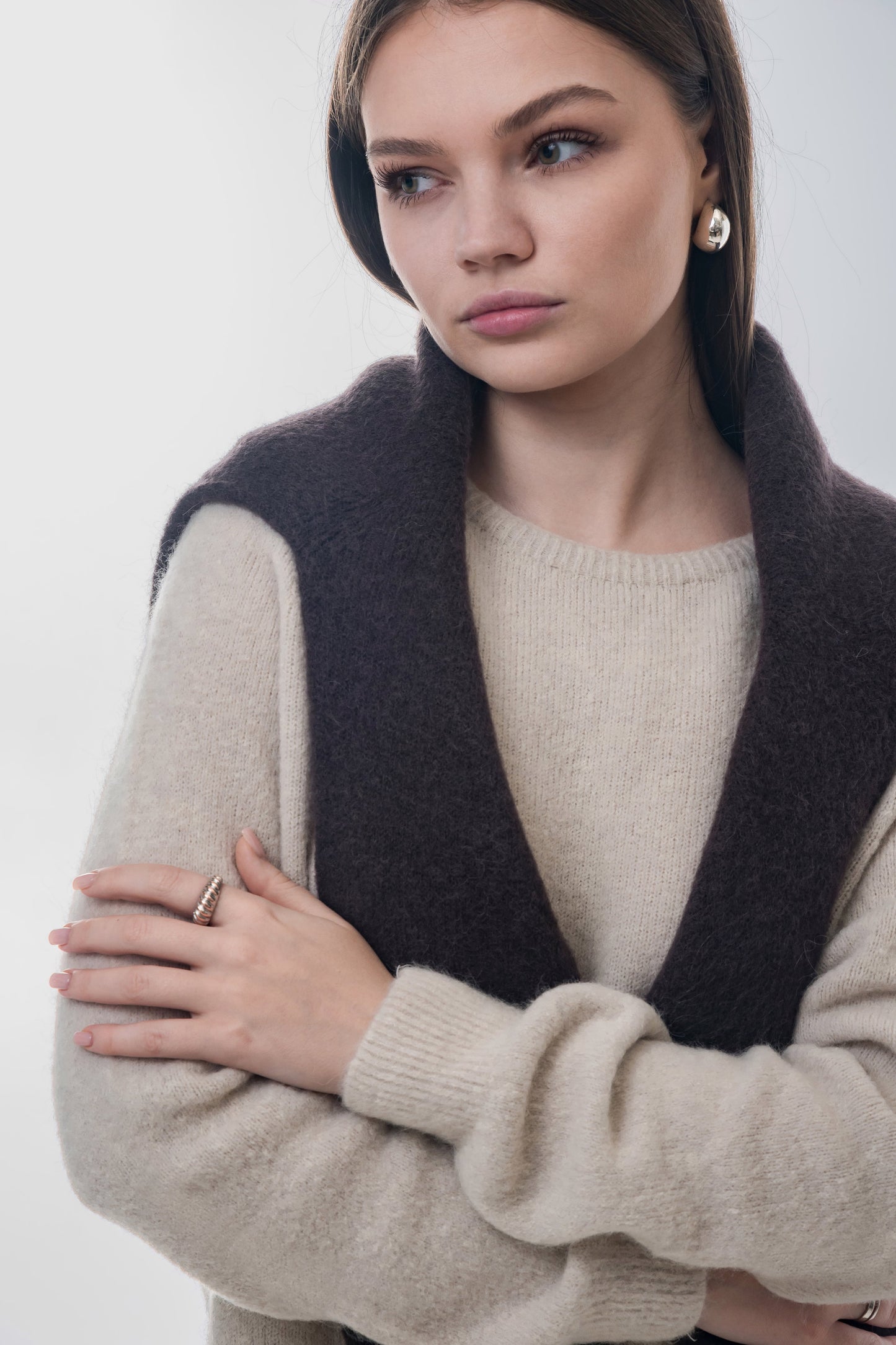 Styling-Variante des hellbeigen Pullovers mit einem dunkelgrauen Pullover lässig über den Schultern 