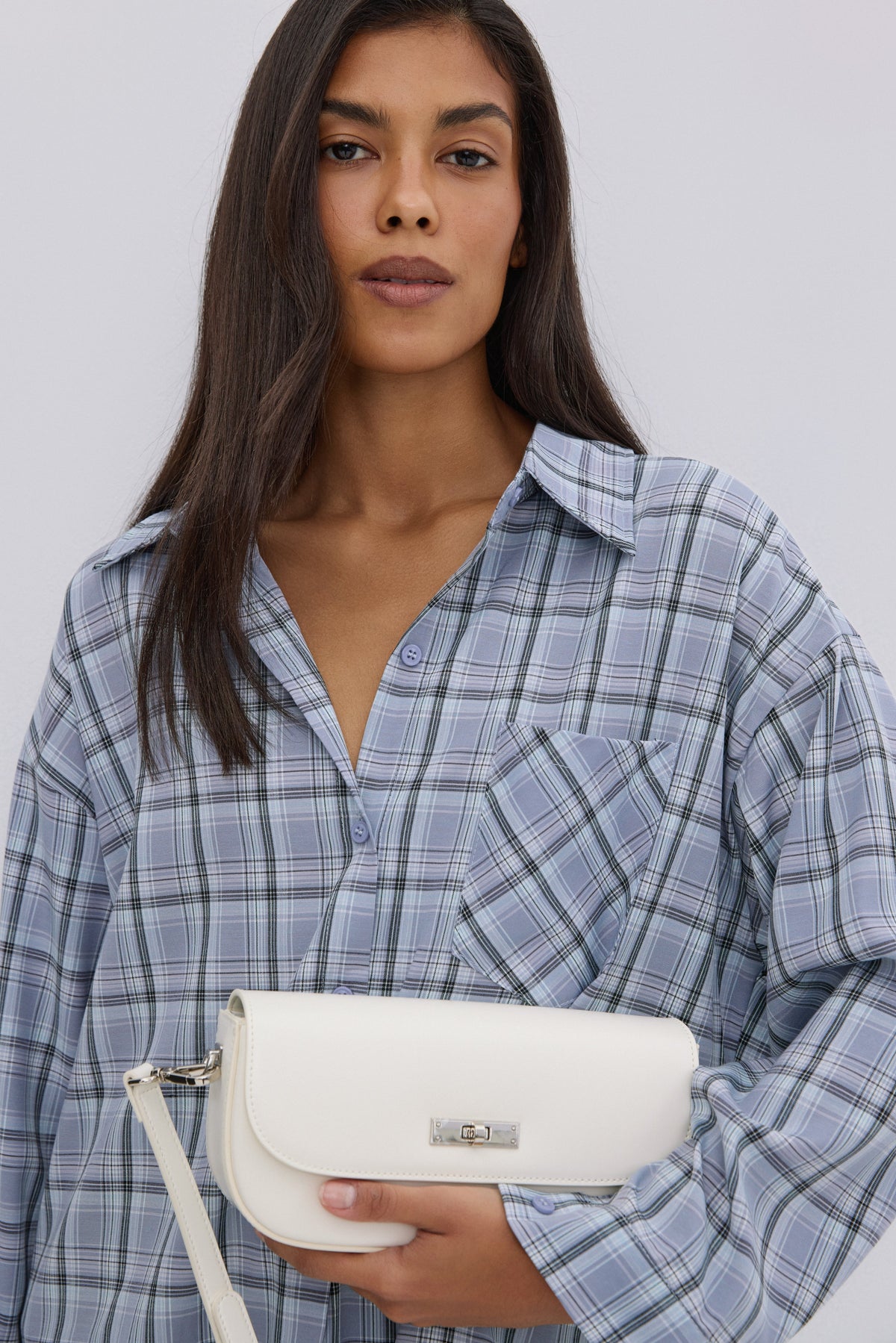 Nahaufnahme des Models in der hellblau karierten Damen-Hemdbluse mit überschnittenen Schultern