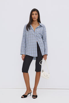 Model präsentiert die lässige Oversize-Passform der hellblau karierten Hemdbluse von Estro