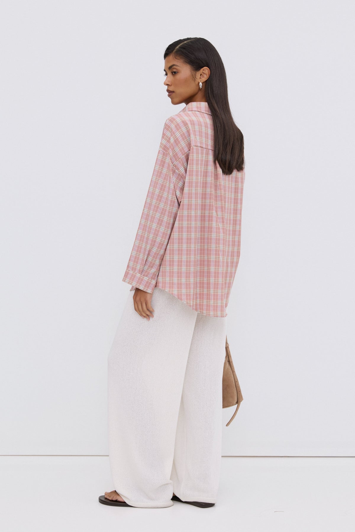 Rückansicht des Models, das die überschnittene, rosa karierte Oversize-Bluse trägt