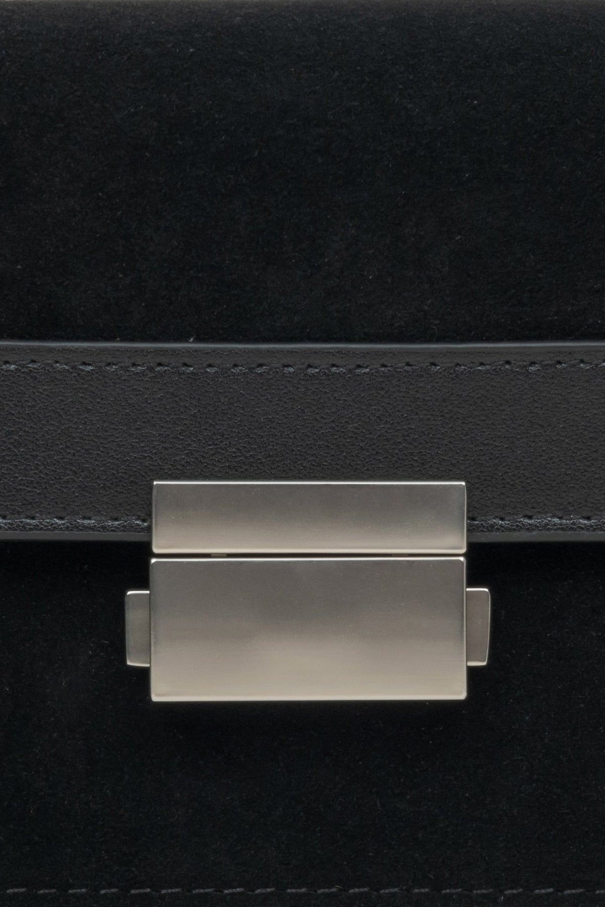 Kompakte Damenhandtasche aus Leder und Velours in Schwarz – Nahaufnahme eines Details.