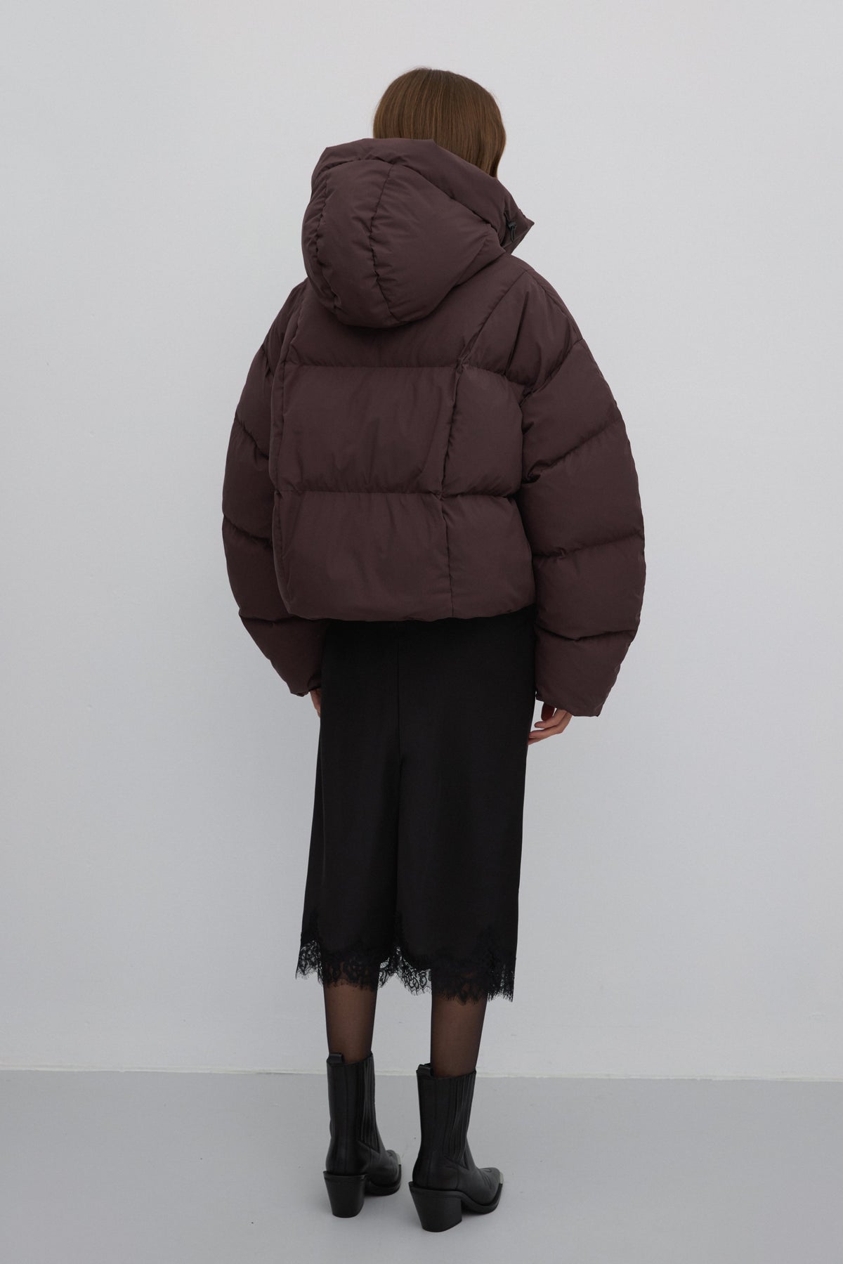 Rückansicht der dunkelbraunen Damen-Pufferjacke, die den kastigen Oversize-Schnitt zeigt