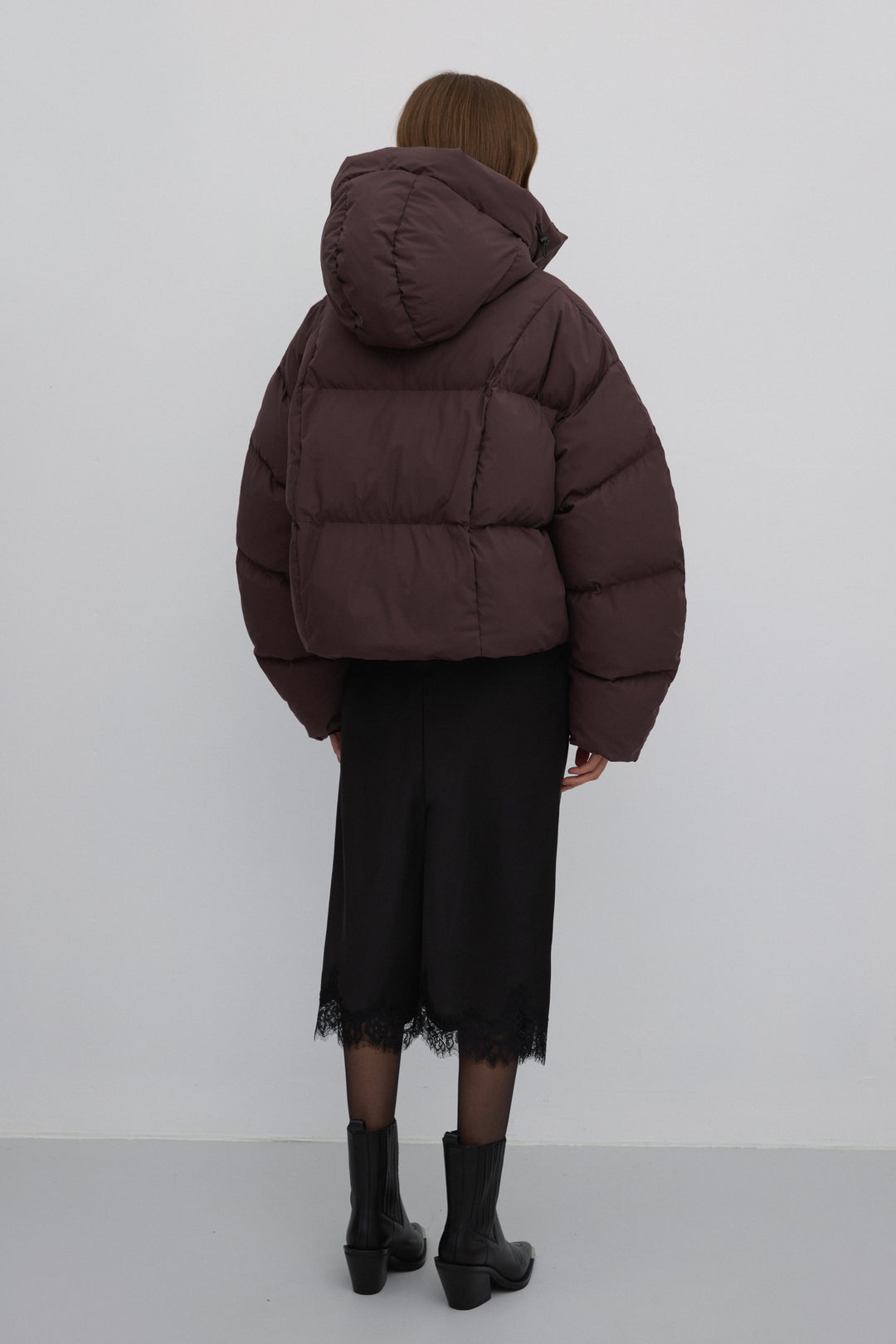 Rückansicht der dunkelbraunen Damen-Pufferjacke, die den kastigen Oversize-Schnitt zeigt
