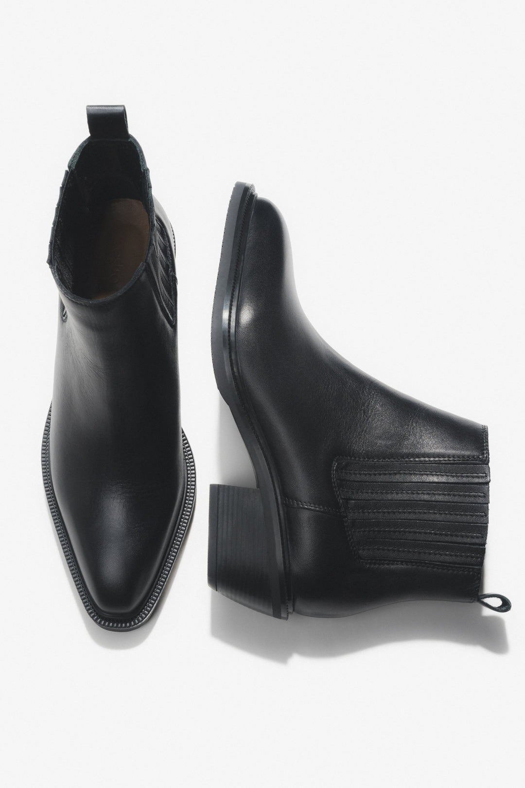 Künstlerische Draufsicht auf das Paar der kurzen schwarzen Cowboystiefel aus Echtleder