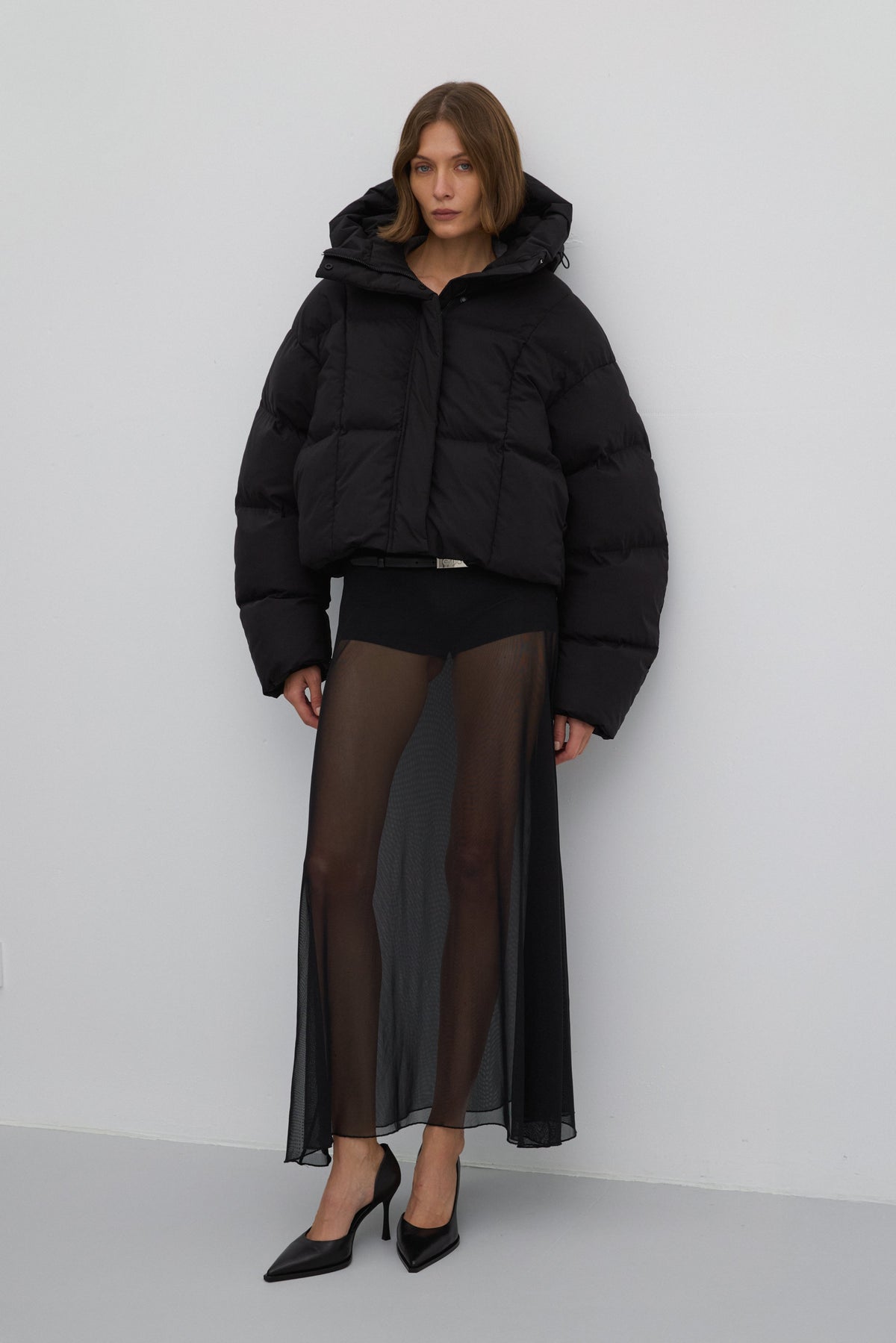 Frontalansicht der geschlossenen schwarzen Winterjacke mit verkürztem Schnitt