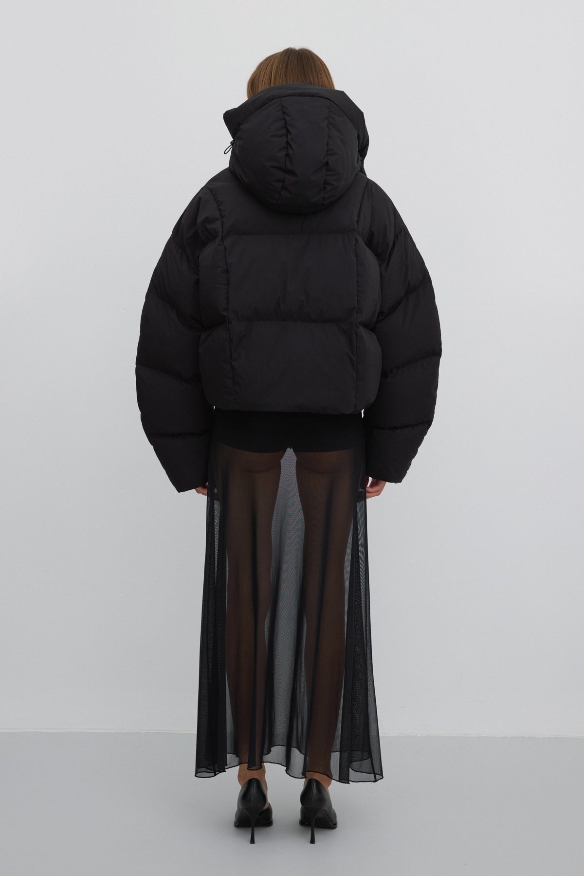 Rückansicht der voluminösen, kurzen schwarzen Oversize-Winterjacke für Damen